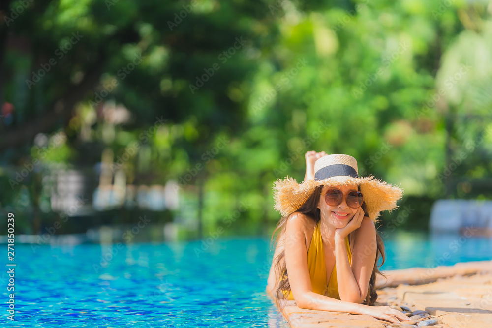 Portrait beautiful young asian woman leisure relax smile and happy around swimming pool in hotel resort