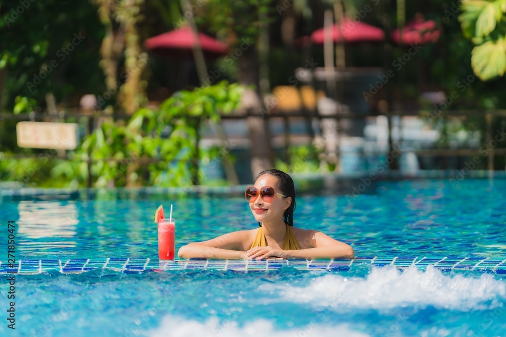 Portrait beautiful young asian woman leisure relax smile with watermelon juice around swimming pool in hotel resort