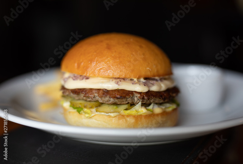 Burger in the plate on black background 