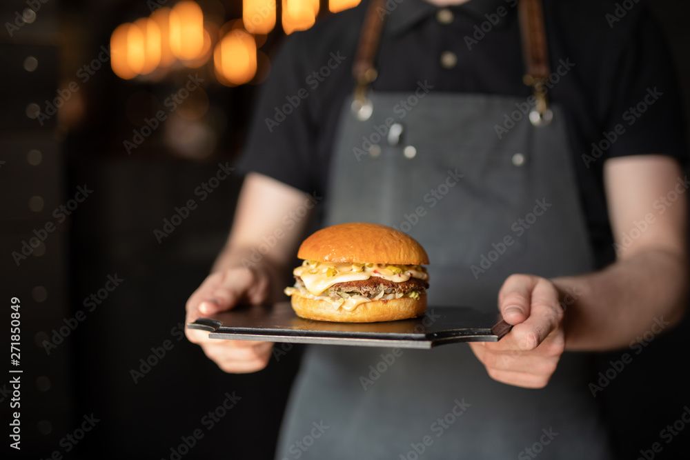 Waiter shot of chef carrying burger for client - obrazy, fototapety, plakaty 