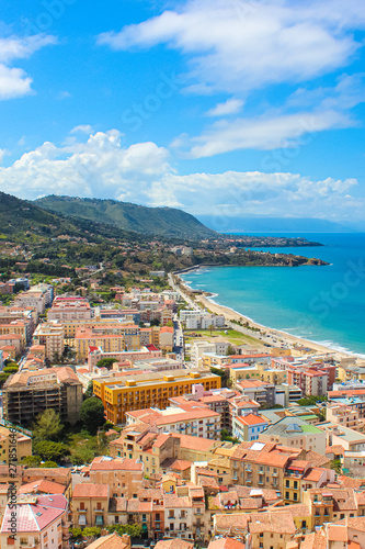 Stunning view of coastal city Cefalu in Sicily, Italy captured on a vertical picture. The city on Tyrrhenian coast surrounded by rocky hills is a popular summer vacation destination