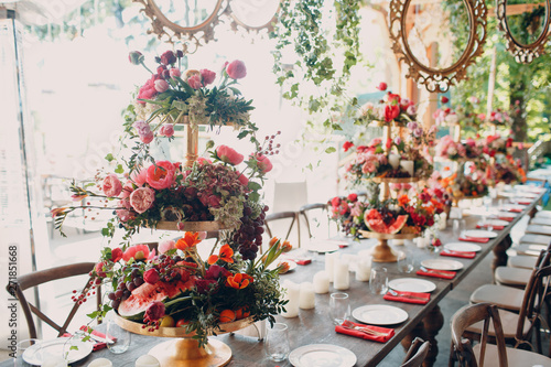 Wedding table flowers with fruits and berries decor in red white pink green colors. photo