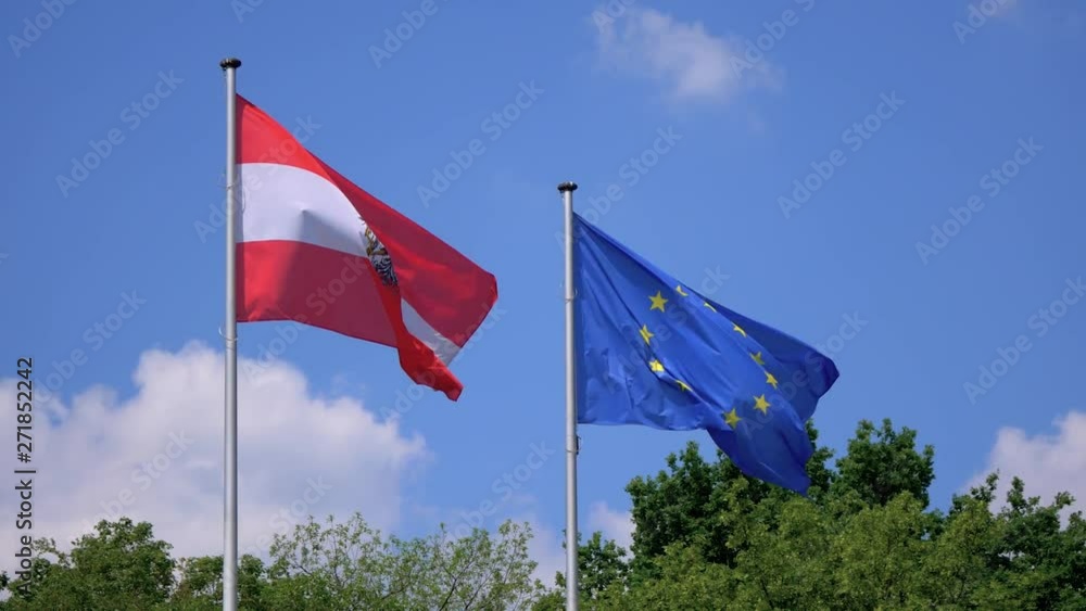 Austria And EU Flag Fluttering Against A Blue Cloudy Sky Austria And EU Flag Fluttering Against A Blue Cloudy Sky