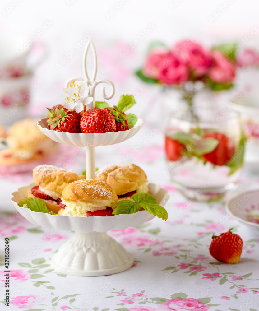 tuł Cream puffs cakes or profiterole filled with whipped cream served with strawberries in plateau tuł Cream puffs cakes or profiterole filled with whipped cream served with strawberries in plateau
