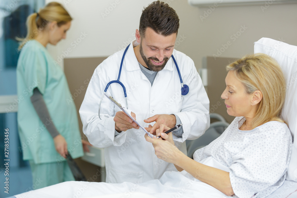 patient in hospital bed signing consent form patient in hospital bed signing consent form