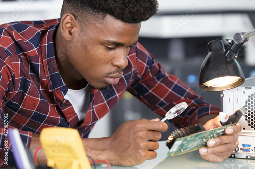 male worker with magnifying glass during electronic photo