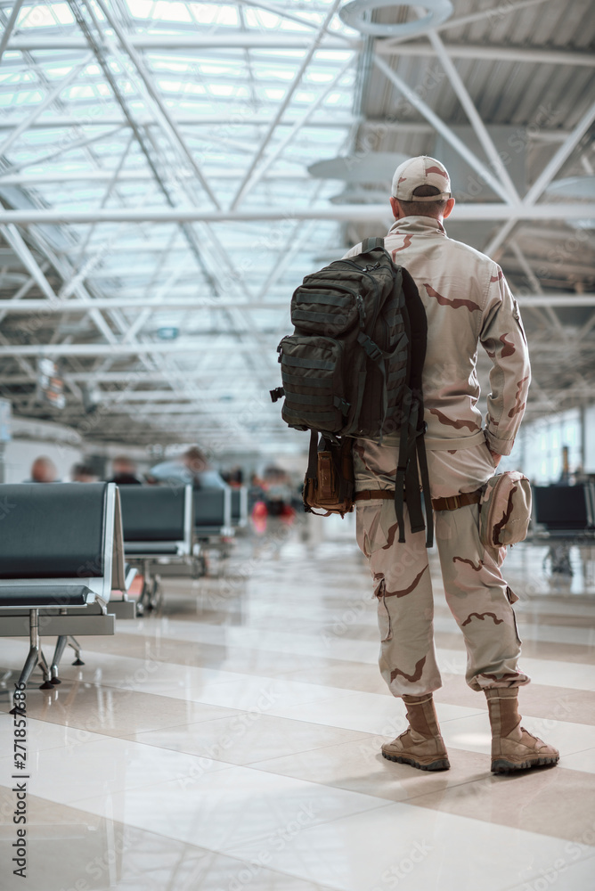 Full length of American soldier in camouflage carrying backpack Full length of American soldier in camouflage carrying backpack