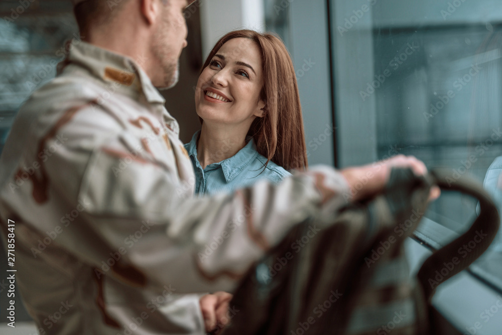 Happy young couple looking at each other while standing near window Happy young couple looking at each other while standing near window