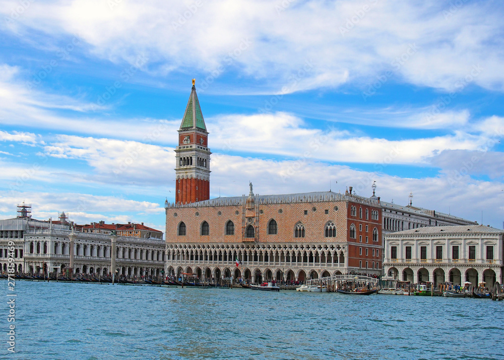 a cityscape view of san marco palace in venice from the sea with clouds and blue sky