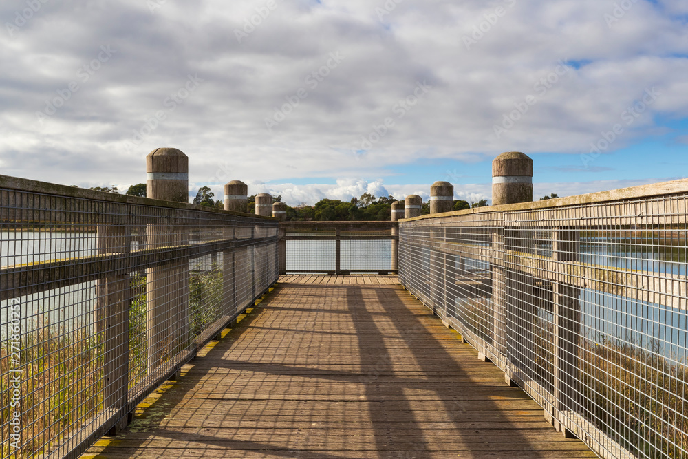A walkway and viewing platform overlooking a lake in a community park.