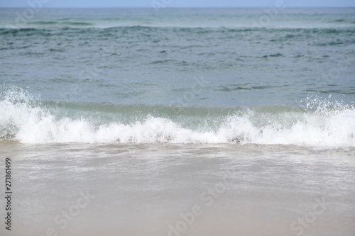 closeup on waves hitting the beach on a sunny summer day