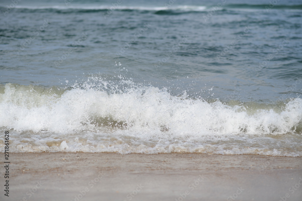 closeup on waves hitting the beach on a sunny summer day