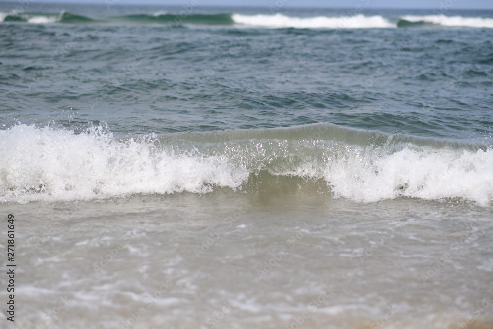 closeup on waves hitting the beach on a sunny summer day closeup on waves hitting the beach on a sunny summer day
