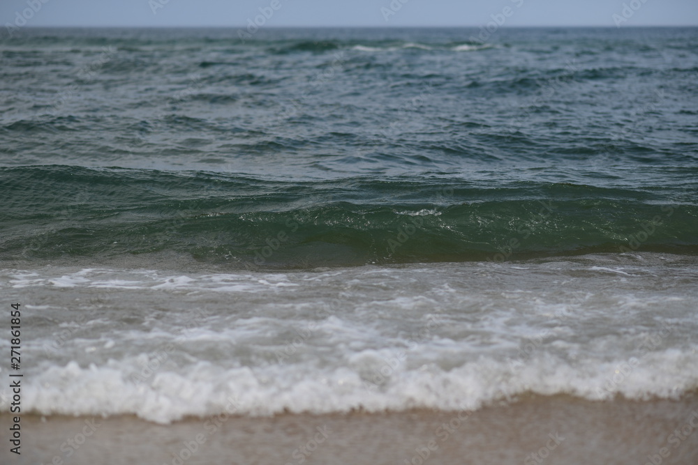 closeup on waves hitting the beach on a sunny summer day closeup on waves hitting the beach on a sunny summer day