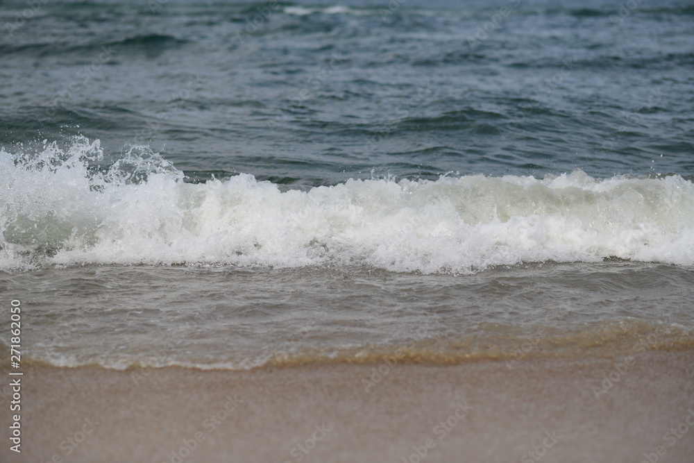 closeup on waves hitting the beach on a sunny summer day closeup on waves hitting the beach on a sunny summer day