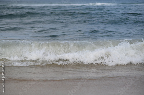 closeup on waves hitting the beach on a sunny summer day