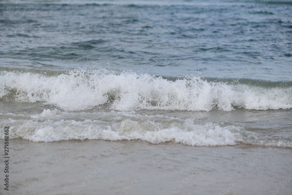 closeup on waves hitting the beach on a sunny summer day closeup on waves hitting the beach on a sunny summer day