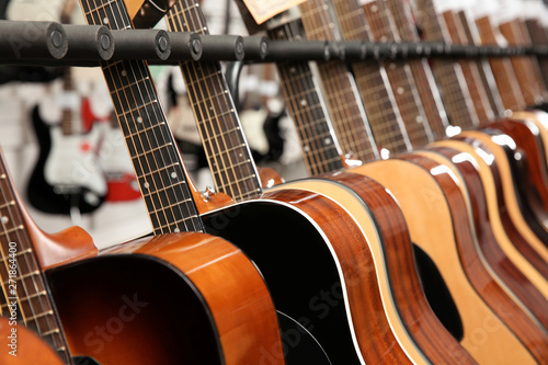 Row of different guitars in music store, closeup