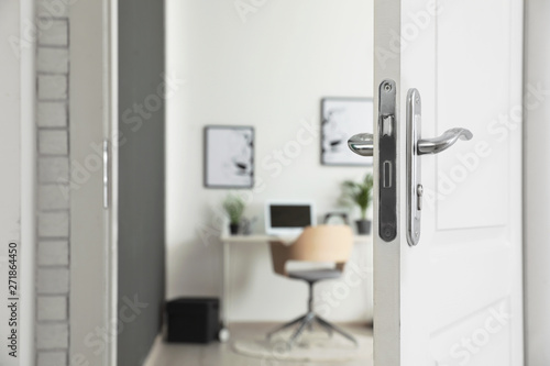 Stylish home office interior, view through open door