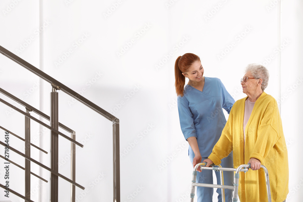 Nurse assisting senior woman with walker in hospital Nurse assisting senior woman with walker in hospital