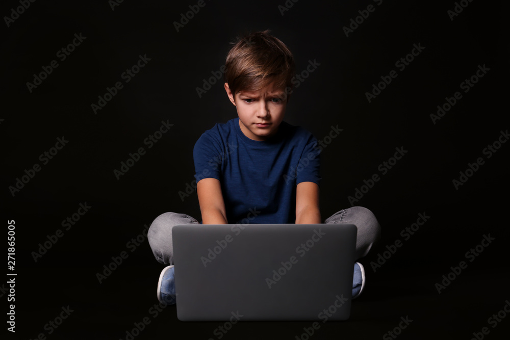 Shocked child with laptop on black background. Danger of internet Shocked child with laptop on black background. Danger of internet