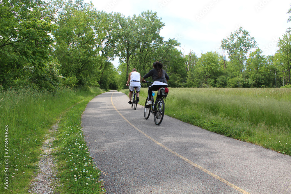Obraz premium Middle-aged couple riding bicycles at Blue Star Memorial Woods in Glenview, Illinois