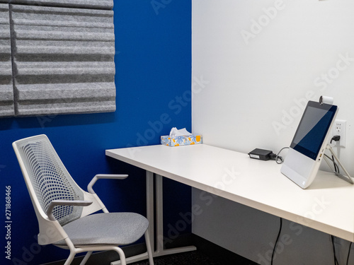 Bright  private office conference room with monitor and teleconference camera