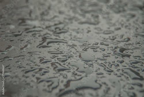 Close up raining water drop on the stainless steel, surface after rainy for background or graphic design.