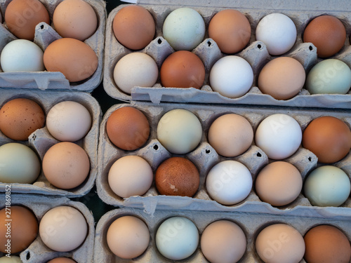 Overhead view of dozen of white and brown eggs sitting in carton