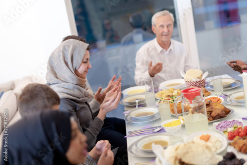 modern multiethnic muslim family praying before having iftar dinner