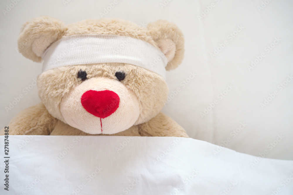 The teddy bear has gauze on the head. Child Injury Concept