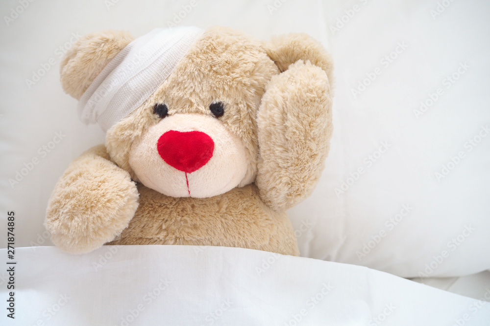 The teddy bear has gauze on the head. Child Injury Concept