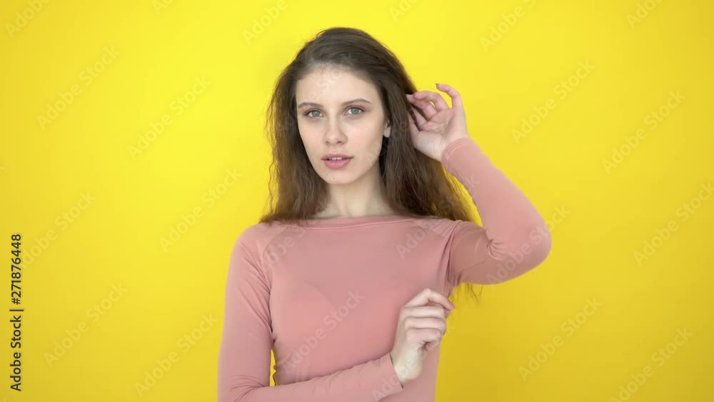 Smiling teen girl in studio. Beautiful woman smiling face looking at camera on yellow background. Portrait of beauty model face. Natural female beauty. Close up of isolated happy woman smiling 4 K Smiling teen girl in studio. Beautiful woman smiling face looking at camera on yellow background. Portrait of beauty model face. Natural female beauty. Close up of isolated happy woman smiling 4 K