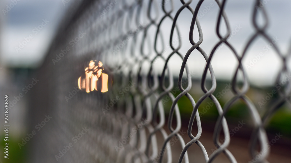 Closeup of chain link fence by railroad tracks Closeup of chain link fence by railroad tracks