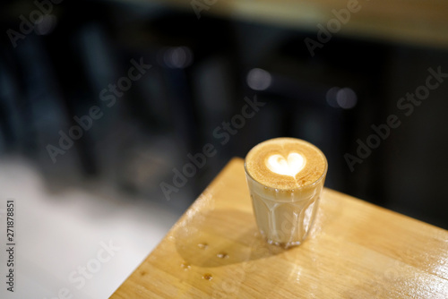 Hot Piccolo latte - A glass of coffee with milk and beautiful heart pattern latte art on wooden table background, Perfect for breakfast time.