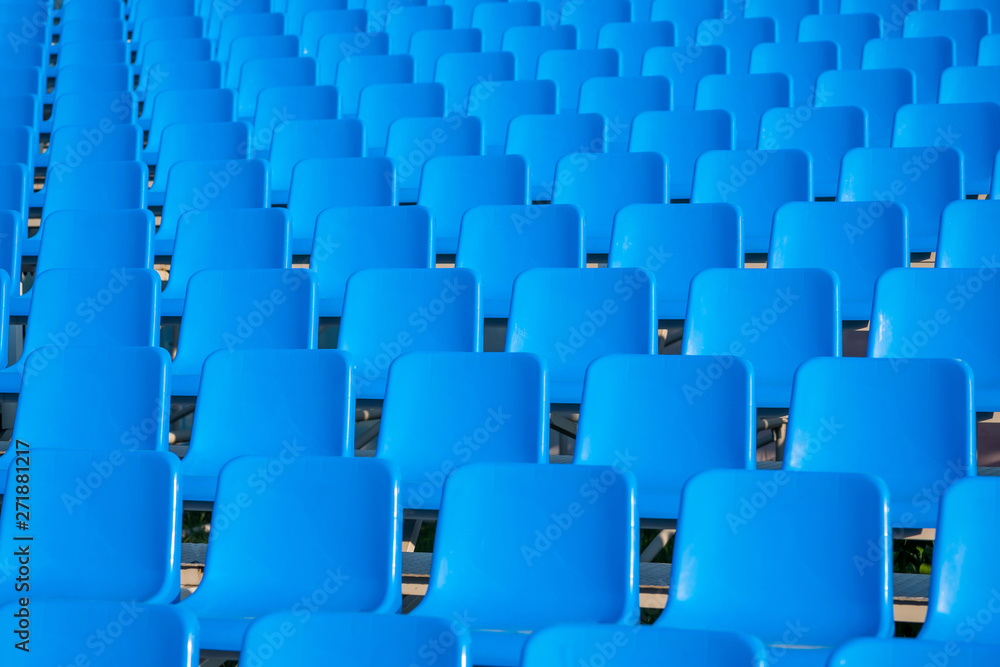 rows of empty blue seats in stadium. empty blue chairs. rows of empty blue seats in stadium. empty blue chairs.