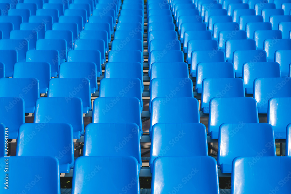 Naklejka premium rzędy pustych niebieskich miejsc na stadionie. puste niebieskie krzesła.