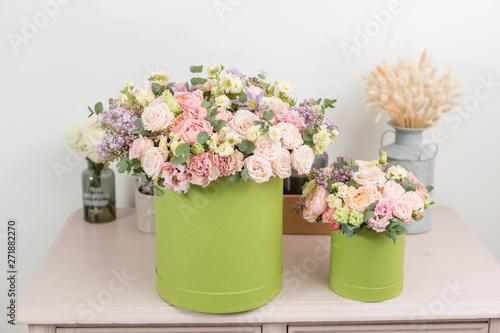 Fototapeta Naklejka Na Ścianę i Meble -  Two Beautiful spring bouquets in head box. Arrangement with mix flowers. The concept of a flower shop, a small family business. Work florist. copy space