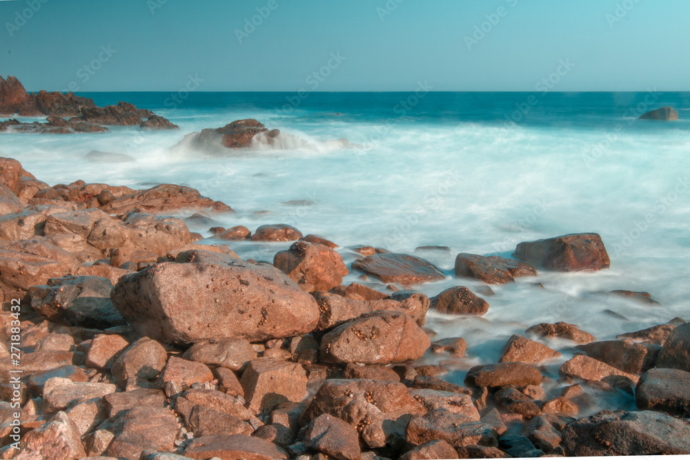 rocky beach with water cloudscape long exposure