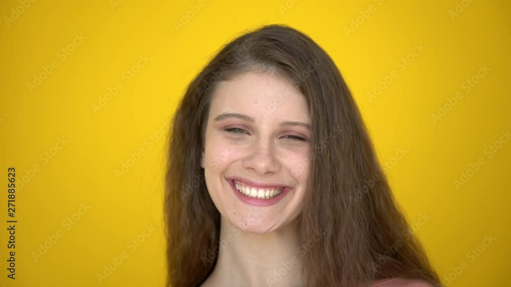 Close portrait of happy caucasian teenage girl smiling laughing on yellow background. teen girl, face of young beautiful woman in studio. laughter, smile Female with positive emotions expression, 4 K Close portrait of happy caucasian teenage girl smiling laughing on yellow background. teen girl, face of young beautiful woman in studio. laughter, smile Female with positive emotions expression, 4 K