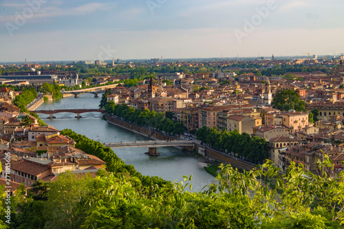 Bridges on the Adige River in Verona, Italy. Bright urban landscape with a bend of the river, bridges, roofs and towers. View from above.