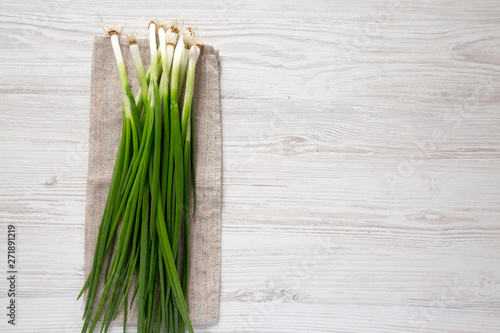 Fresh green onions on a white wooden surface  top view. From above  overhead  flat lay. Copy space.