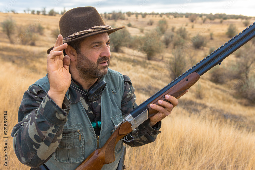 Hunter with a hat and a gun in search of prey in the steppe Hunter with a hat and a gun in search of prey in the steppe