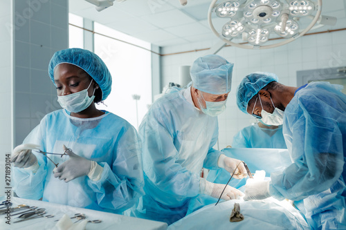 Vászonkép experienced doctors performing organ removal or transplant in the clinic