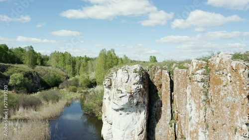 4k footage of Russia nature; river valley, high, steep rocky slopes; relict vegetation, natural reserve of rare plants; place for climbing and active lifestyle; aerial view; drone flying down to river
