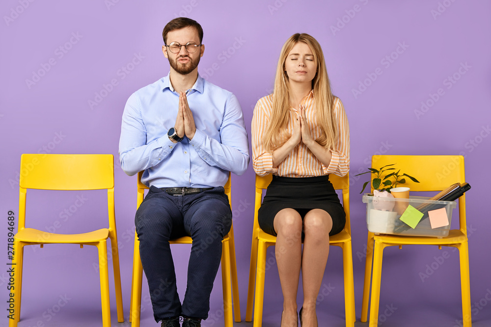 Obraz premium sorrowful blonde girl and man asking for forgiveness and to give them one more chance to correct mistakes, holding pleading hands and waiting for job interview