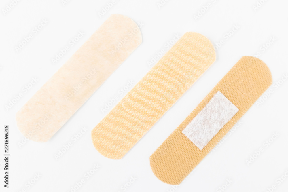 Adhesive plasters of various skin tones from light beige to saturated. A set of adhesive plasters on a white background. Necessary items for summer activities, treatment of wounds, scratches. Adhesive plasters of various skin tones from light beige to saturated. A set of adhesive plasters on a white background. Necessary items for summer activities, treatment of wounds, scratches.
