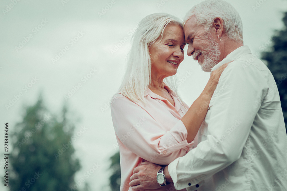 Obraz premium Pleasant nice aged couple hugging each other