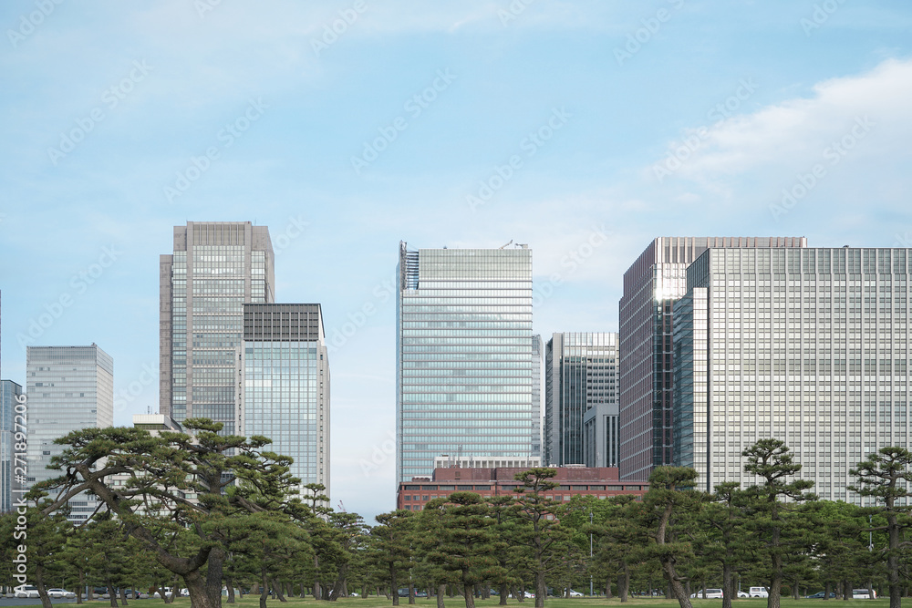 A group building with tree and road in a modern city in Tokyo. - Image