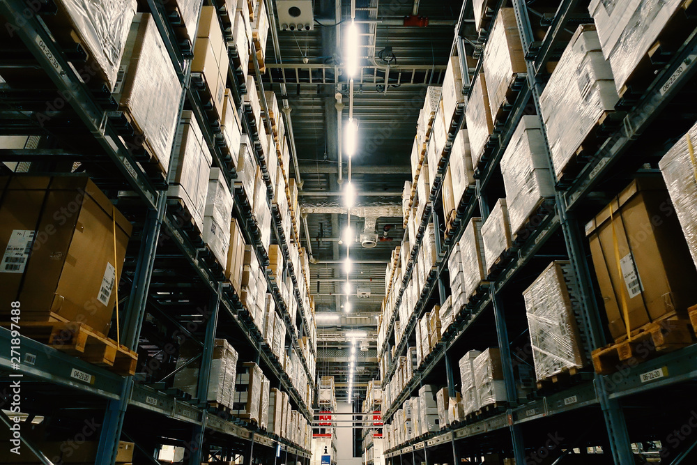 Large wharehouse with rows of shelves and goods boxes.